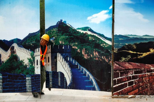 Một công nhân nhìn qua hàng rào tại công trình xây dựng nhà ga Bát Đạt Lĩnh. Ảnh: REUTERS 