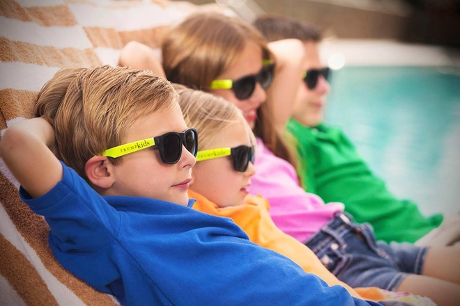 Trong ảnh là các vị khách nhí tắm nắng bên hồ bơi trong khách sạn ở Las Vegas và đeo kính Trump Kids.