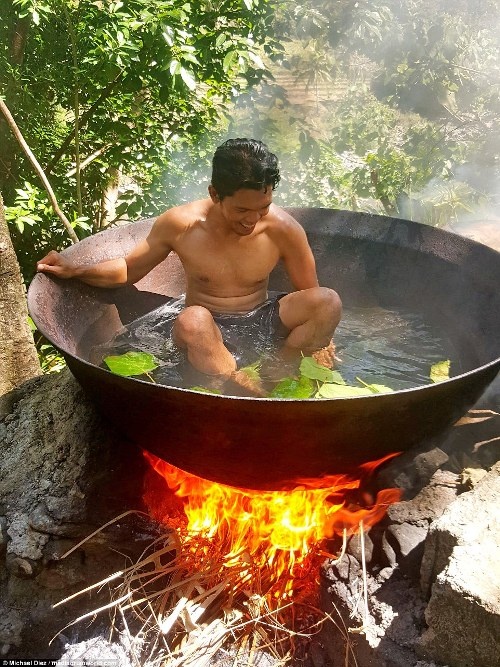 Michael đang ngâm mình trong bể Kawa với ngọn lửa cháy ngùn ngụt bên dưới làm nước trong bể nóng dần. Loại bể tắm này là một trong những điều thu hút khách đến với Tibiao - điểm du lịch sinh thái nổi tiếng của Philippines. 