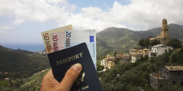 Man's hand holding passport and euro currency