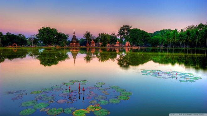 Đâu đâu trên đất nước chùa tháp cũng là những ngôi đền cổ kính. Hình ảnh được ghi lại ở Ban Kluai, Sukhothai trong ánh hoàng hôn tím xen lẫn vàng in hình xuống mặt nước, điểm xuyết những bông hoa súng.