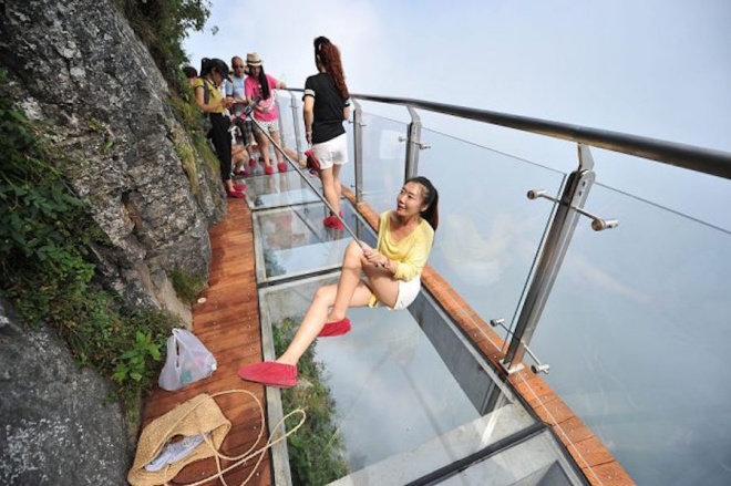 Du khách chụp ảnh trên cầu kính, nằm tại vách đá của núi Thiên Môn Sơn, tỉnh Hồ Nam, Trung Quốc. Ảnh: VCG. 