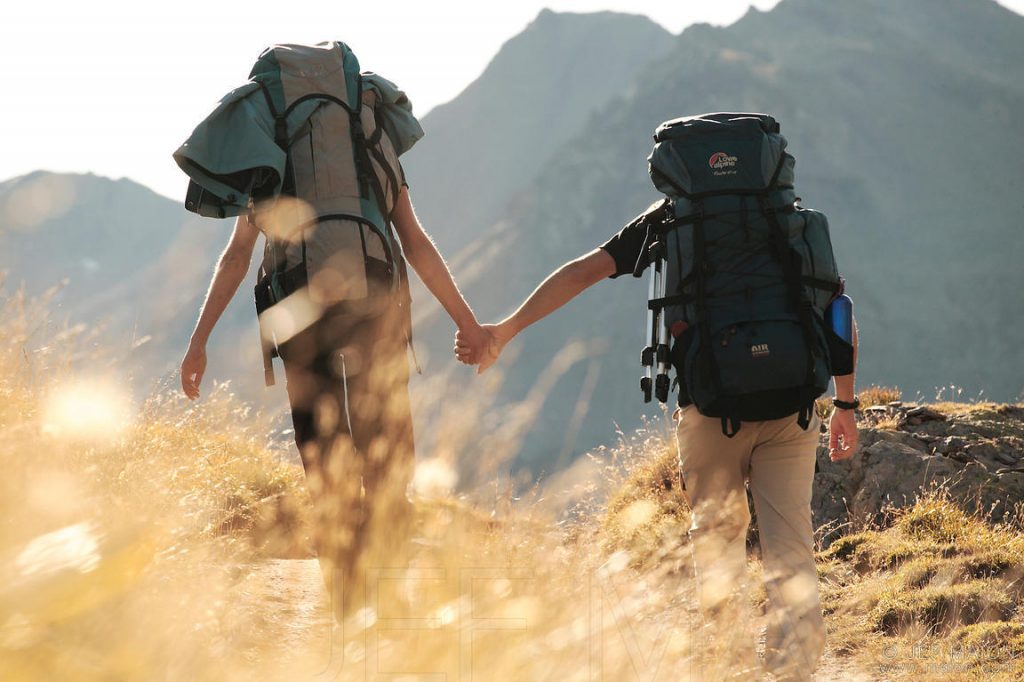 Backpackers couple walking hand in hand