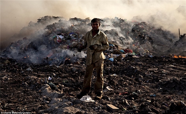 Các công nhân xử lý rác thải chất đống như núi ở đây bằng cách đốt. 