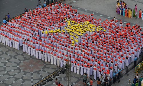 Các nữ sinh cùng hàng nghìn cô gái trẻ tham gia xếp hình cờ đỏ sao vàng với chiếc áo dài trắng và chiếc nón lá truyền thống. 