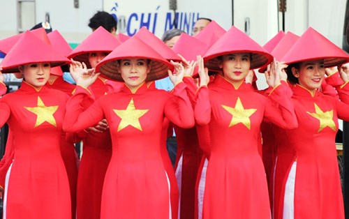 Những cô gái Sài Gòn đẹp rạng rỡ trong chiếc áo dài cờ đỏ sao vàng và chiếc nón lá truyền thống. Du khách quốc tế không ngớt trầm trồ, ấn tượng khi được tham gia lễ hội áo dài lần thứ 4 ở TP HCM. 