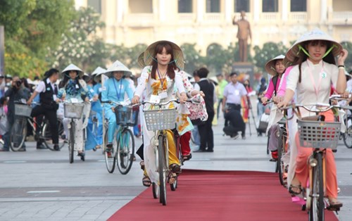 Những cô gái Sài Gòn đẹp rạng rỡ trong chiếc áo dài cờ đỏ sao vàng và chiếc nón lá truyền thống. Du khách quốc tế không ngớt trầm trồ, ấn tượng khi được tham gia lễ hội áo dài lần thứ 4 ở TP HCM. 