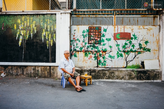 Một cụ già bắc ghế, ngồi uống nước tận hưởng không gian yên tĩnh trong con hẻm số 5A Nguyễn Đình Chiểu 