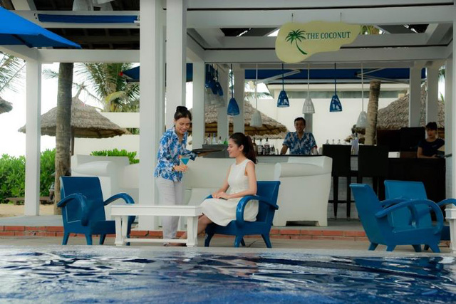 Cô dừng chân tại The Coconut – bar bên bể bơi của Sunrise Premium Resort & Spa Hội An để thưởng thức một ly cocktail mát lạnh và trải nghiệm không gian tuyệt vời.