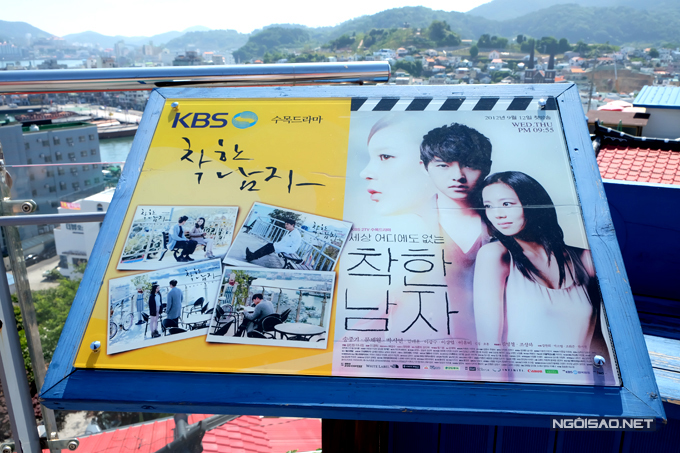 Tấm poster với hình ảnh hai diễn viên trong phim được đặt cạnh hàng ghế gỗ để quảng bá cho du lịch của Dongpirang. 