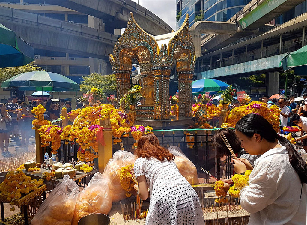 Thăm đền Erawan: Công trình này nằm cạnh khu mua sắm nhộn nhịp ở trung tâm Bangkok. Hàng ngày, có rất đông người tới đây lễ bái khiến cho ngôi đền ngập trong khói hương, vòng hoa và tiếng nhạc từ các vũ công biểu diễn các điệu múa truyền thống. Ảnh: Getty Images.